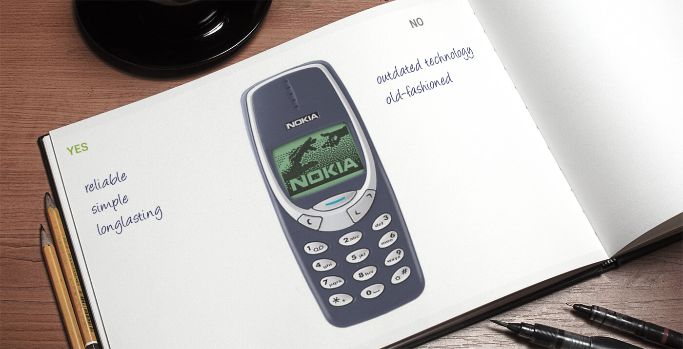 Open book with image of nokia 331 phone. On the left is reads reliable, simple, longlasting. On the right it reads outdated technology and old-fashioned 