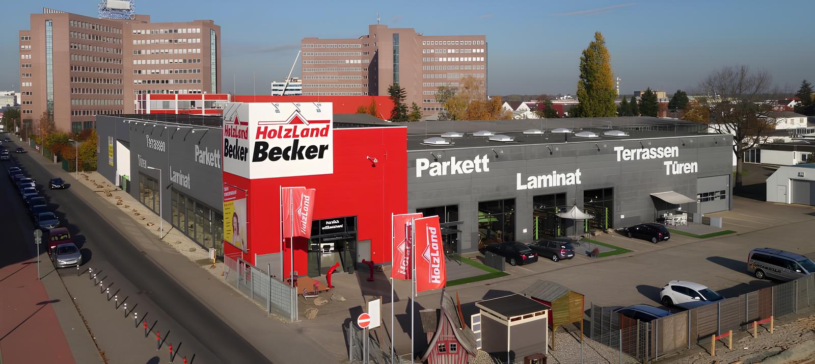 Exterior view of the HolzLand Becker store and showroom with parking area and product displays.