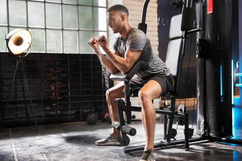 Man using a Christopeit Sport rowing machine at home in a bright living space.