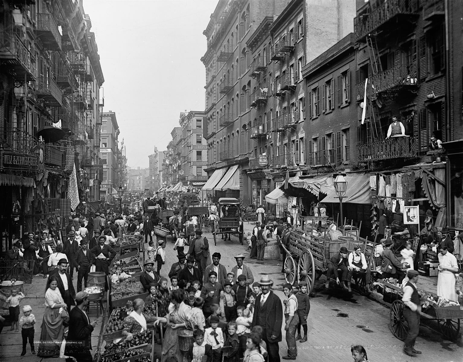 a crowded street in 1900s New York, black and white photo